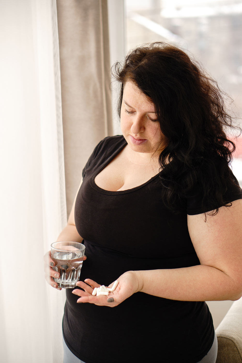 woman holding capsules in heer hand